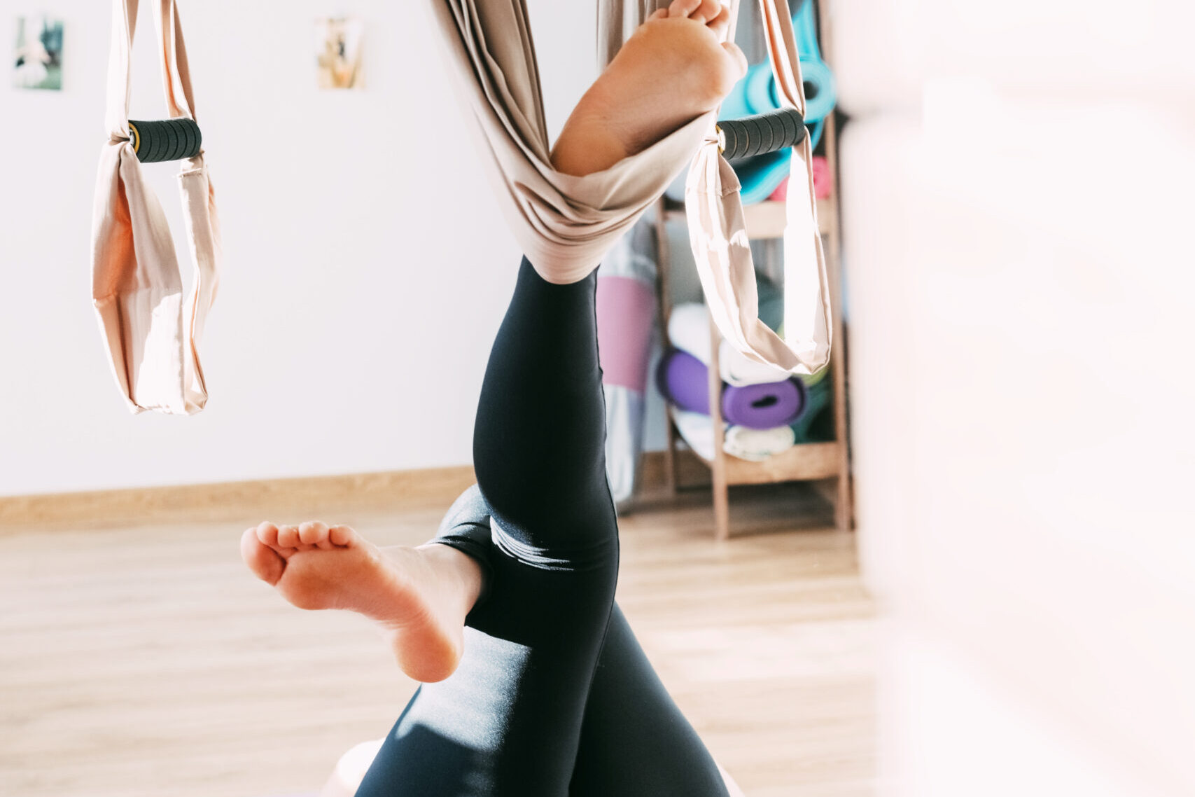 Close-up of the legs of a girl practicing aero yoga. Fitness, sports, yoga. Healthy lifestyle concept