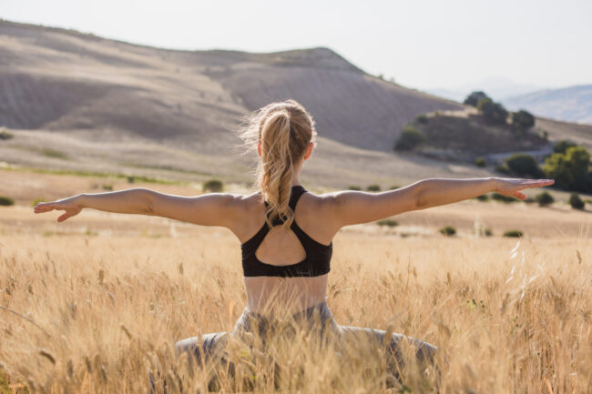 pretty-woman-concentrating-meditating-field